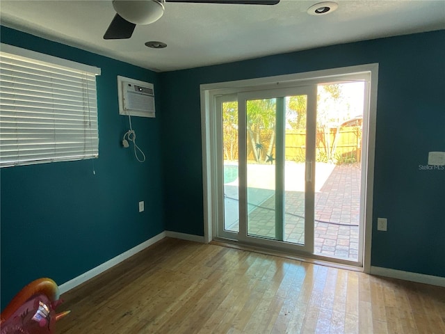 entryway featuring ceiling fan, wood-type flooring, and an AC wall unit