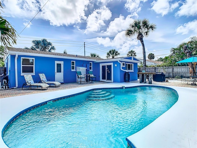 view of swimming pool with a patio area and an outbuilding