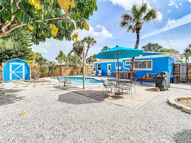 view of pool featuring a storage unit and a patio