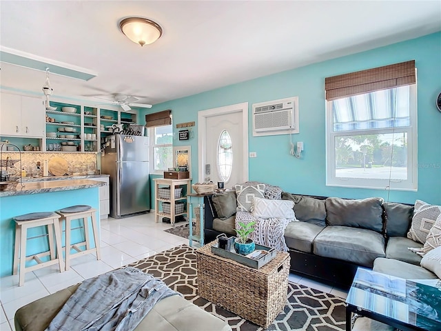 living room featuring a wall mounted air conditioner, ceiling fan, a healthy amount of sunlight, and light tile patterned floors