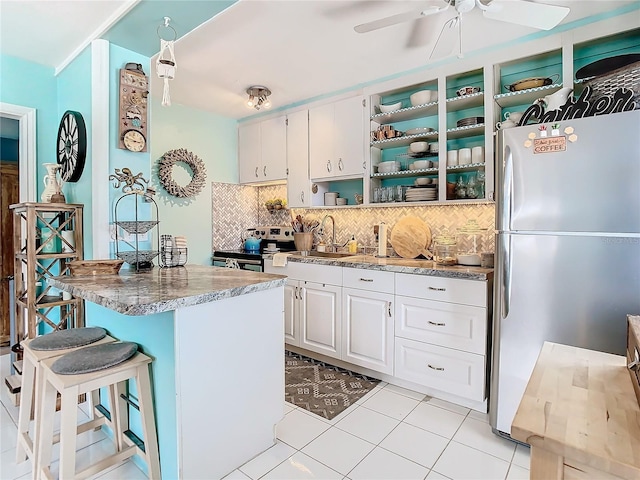 kitchen with backsplash, white cabinetry, sink, and appliances with stainless steel finishes