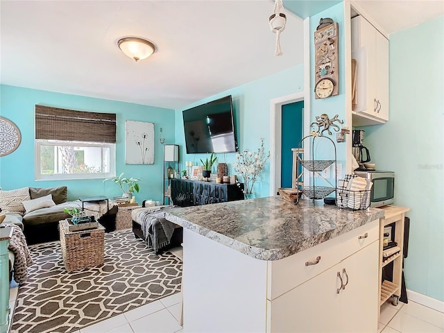 kitchen featuring white cabinets, light tile patterned floors, and kitchen peninsula