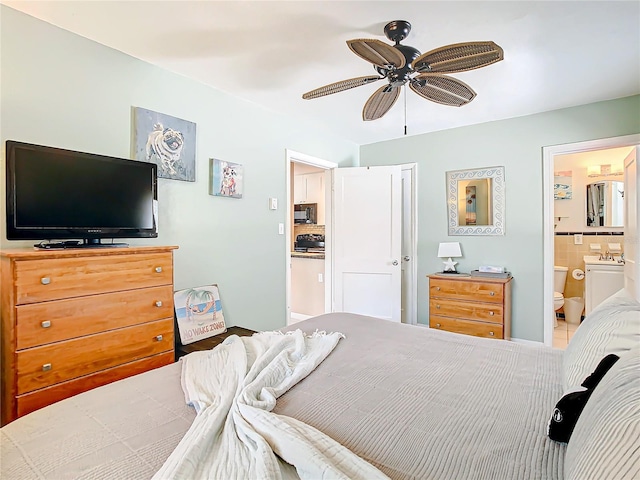 bedroom with ensuite bathroom, sink, and ceiling fan