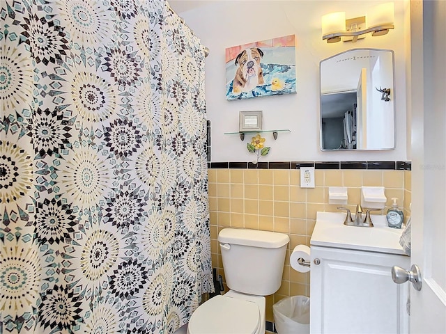 bathroom with vanity, curtained shower, toilet, and tile walls