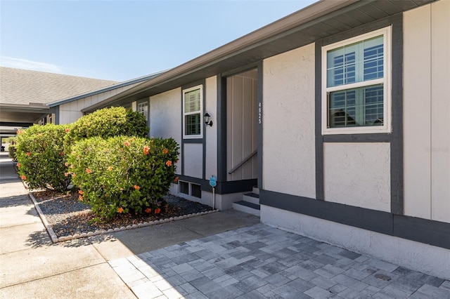 view of exterior entry with a patio area