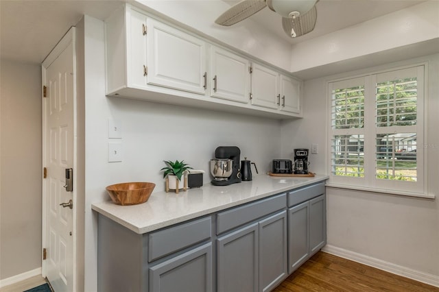 kitchen featuring white cabinets, dark hardwood / wood-style floors, ceiling fan, and gray cabinetry