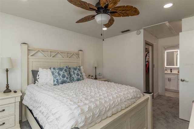 carpeted bedroom featuring a closet, connected bathroom, ceiling fan, and sink