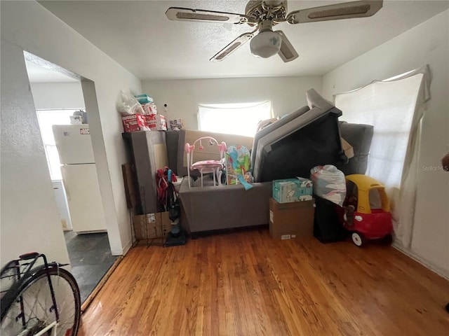 bedroom featuring hardwood / wood-style flooring, ceiling fan, and white refrigerator