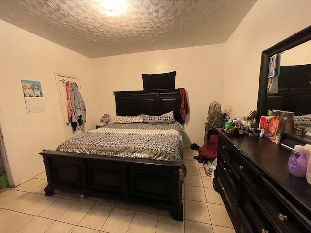 bedroom featuring light tile patterned flooring and a textured ceiling