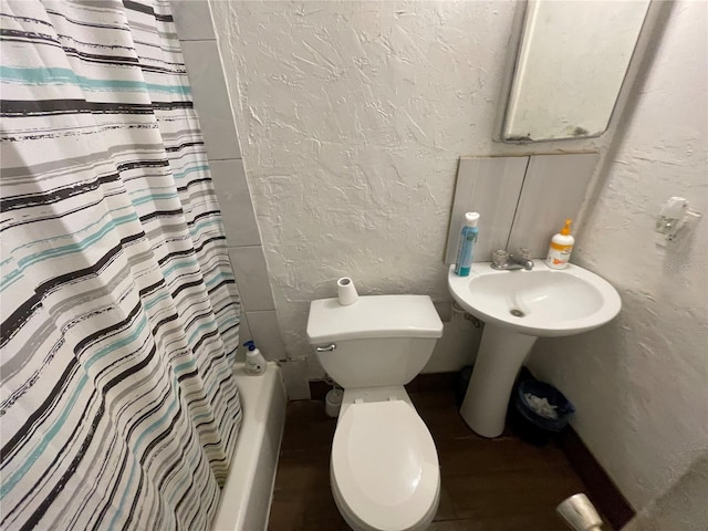 bathroom featuring shower / bathtub combination with curtain and toilet