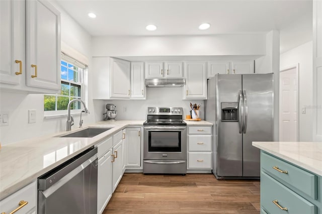 kitchen featuring white cabinets, light stone countertops, sink, and appliances with stainless steel finishes