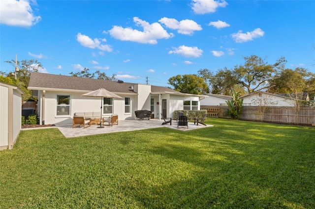 back of house with an outdoor living space, a yard, and a patio