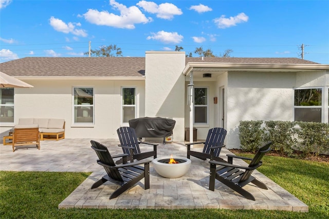 rear view of property with a patio and an outdoor fire pit