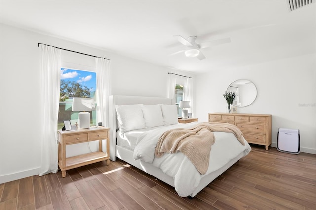 bedroom with multiple windows, ceiling fan, and dark hardwood / wood-style floors