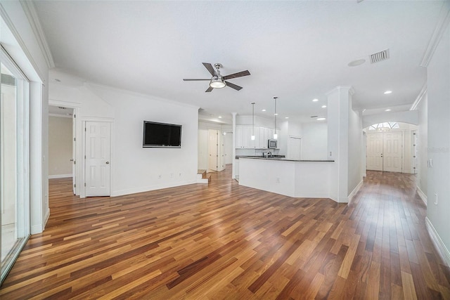 unfurnished living room with ceiling fan, wood-type flooring, and crown molding