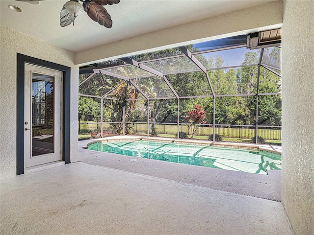 view of pool with ceiling fan, a patio area, and glass enclosure