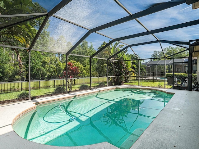 view of swimming pool with a lawn and glass enclosure