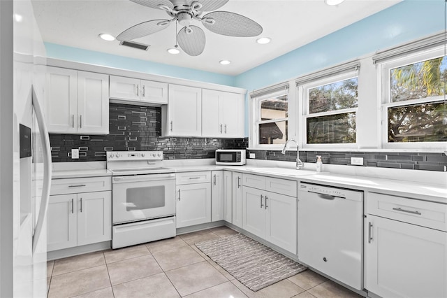 kitchen with backsplash, white appliances, ceiling fan, sink, and white cabinets