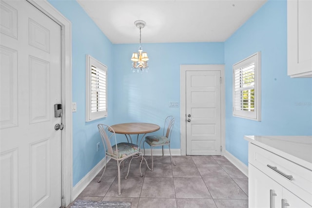 tiled dining space featuring a notable chandelier