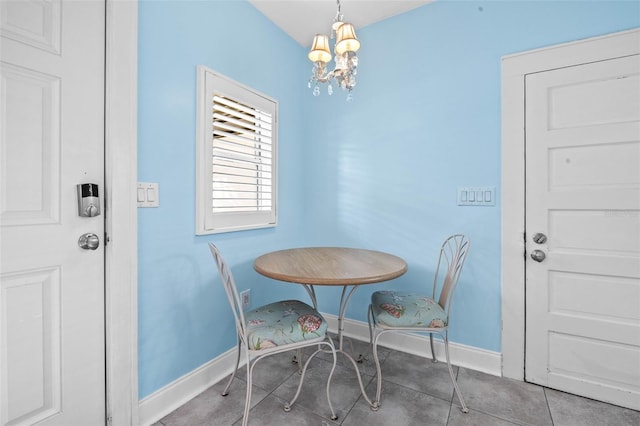 dining space with tile patterned floors and a notable chandelier