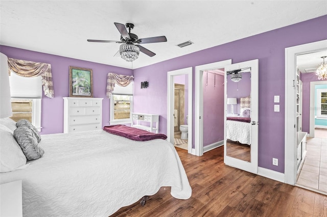 bedroom with ensuite bath, ceiling fan, wood-type flooring, multiple windows, and a closet