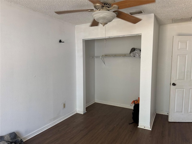 unfurnished bedroom with ceiling fan, dark wood-type flooring, and a textured ceiling