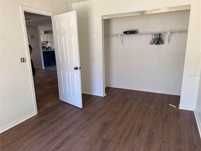 unfurnished bedroom with a closet and dark hardwood / wood-style floors