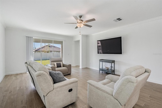 living room featuring hardwood / wood-style flooring, ceiling fan, and ornamental molding