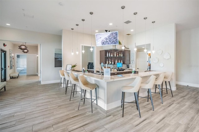 kitchen with a breakfast bar area, kitchen peninsula, and hanging light fixtures