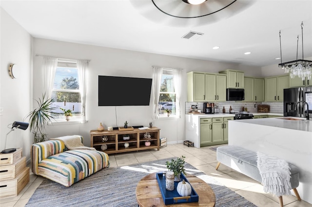 living room featuring light tile patterned floors, sink, and a wealth of natural light