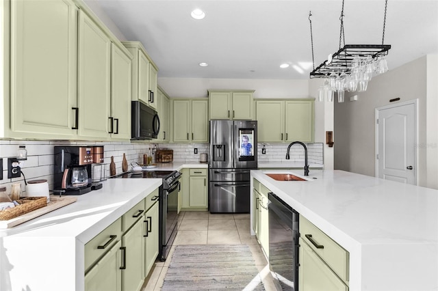 kitchen featuring light tile patterned flooring, sink, green cabinets, and black appliances