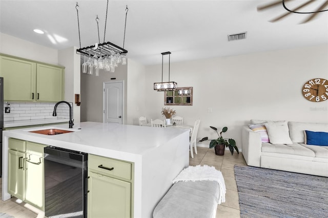 kitchen featuring tasteful backsplash, sink, hanging light fixtures, and green cabinetry