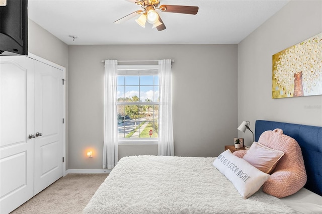 carpeted bedroom featuring a closet and ceiling fan