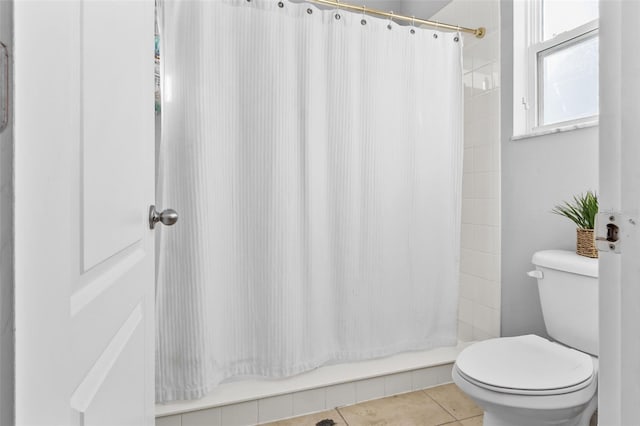 bathroom with curtained shower, tile patterned flooring, and toilet