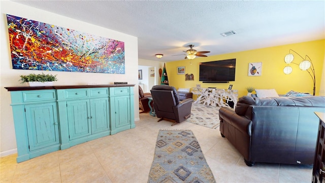 living room featuring ceiling fan and a textured ceiling