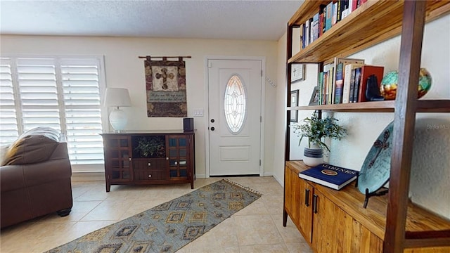 entrance foyer with light tile patterned flooring and a textured ceiling