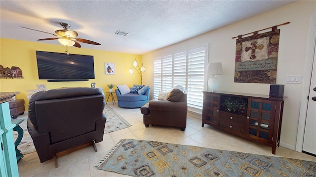 tiled living room with a textured ceiling and ceiling fan