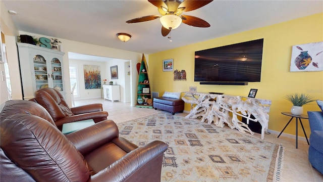 tiled living room with built in shelves and ceiling fan