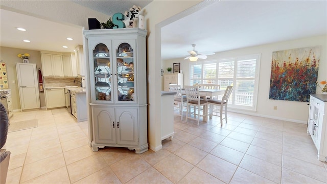 kitchen with ceiling fan, decorative backsplash, light tile patterned floors, and vaulted ceiling