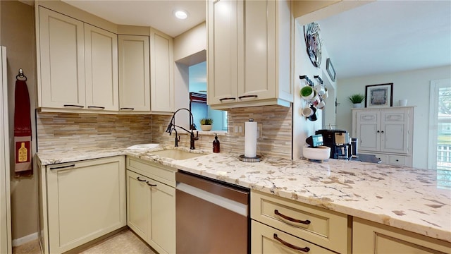 kitchen featuring decorative backsplash, dishwasher, sink, and cream cabinetry