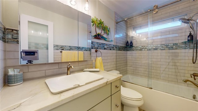 full bathroom with tasteful backsplash, enclosed tub / shower combo, toilet, vanity, and tile walls