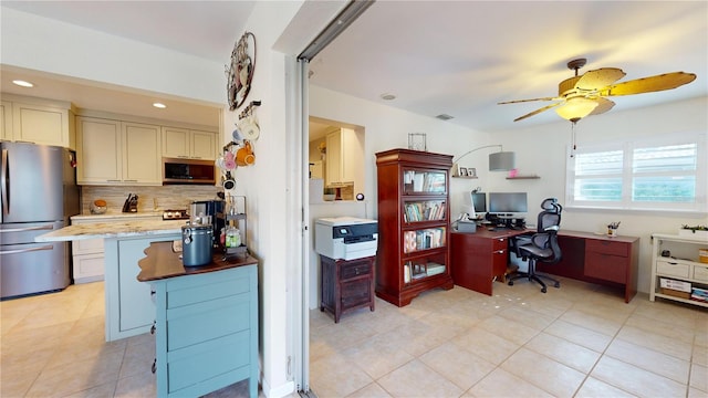 kitchen featuring ceiling fan, light stone countertops, stainless steel appliances, backsplash, and a breakfast bar area