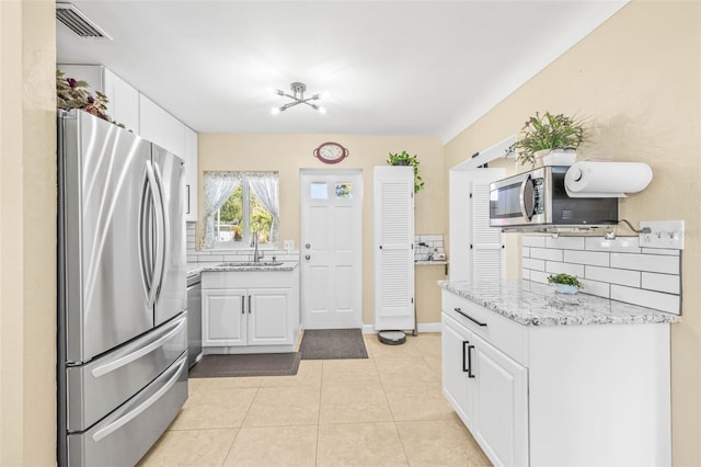 kitchen with backsplash, sink, white cabinets, and appliances with stainless steel finishes