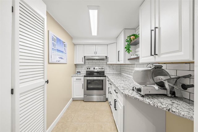 kitchen featuring backsplash, light stone counters, light tile patterned floors, white cabinets, and stainless steel range with electric cooktop