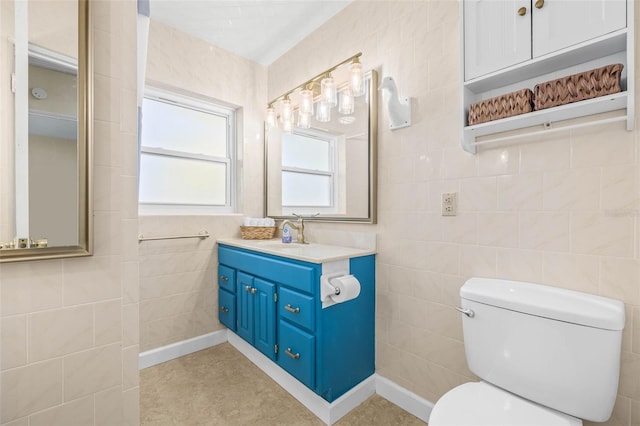 bathroom with vanity, tile walls, and toilet