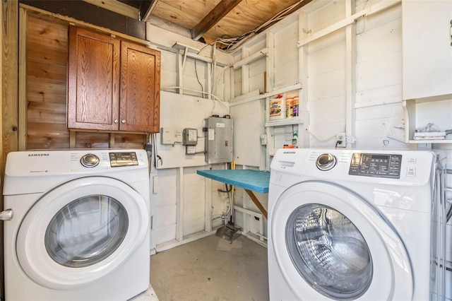 clothes washing area featuring electric panel, cabinets, and washing machine and dryer