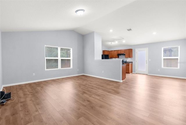 unfurnished living room featuring light wood-type flooring and lofted ceiling