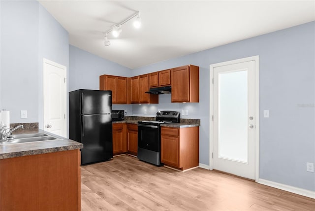 kitchen featuring sink, black appliances, vaulted ceiling, and light hardwood / wood-style floors