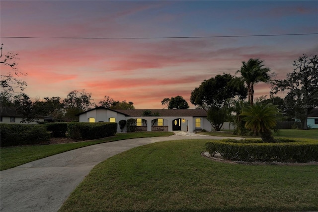 ranch-style home featuring a lawn