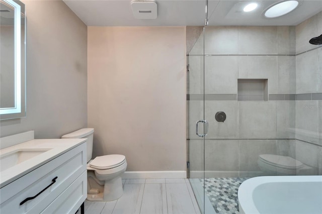 bathroom featuring vanity, toilet, and a shower with shower door